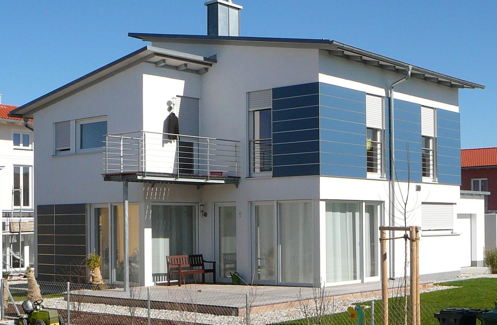 A white house with blue shutters and a balcony