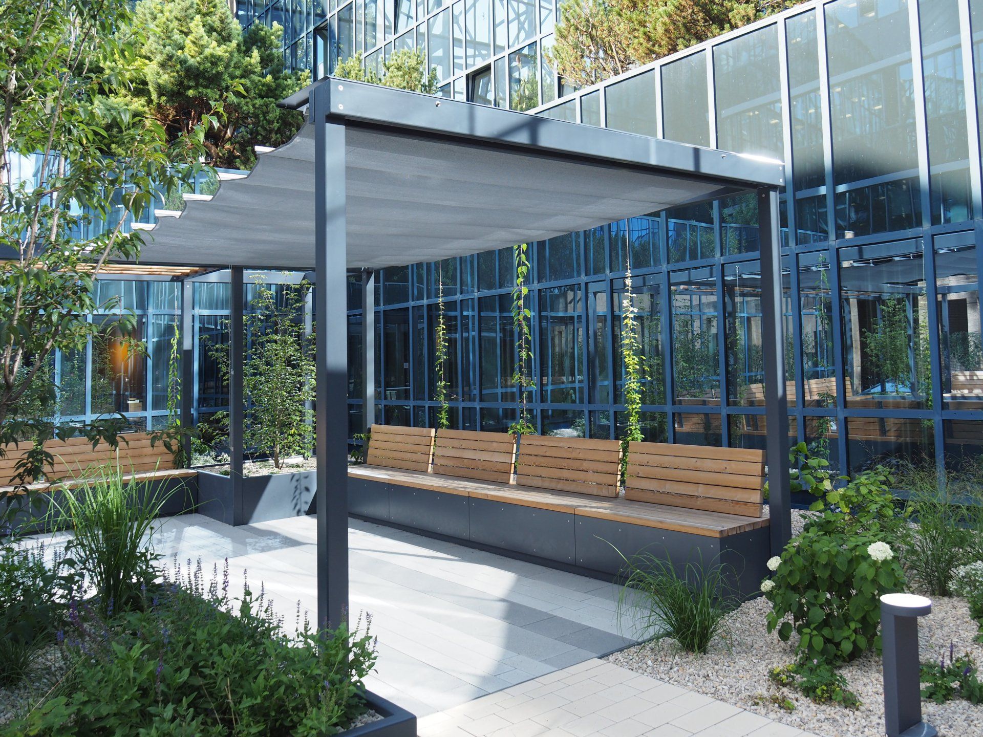 There is a bench under a canopy in front of a building.