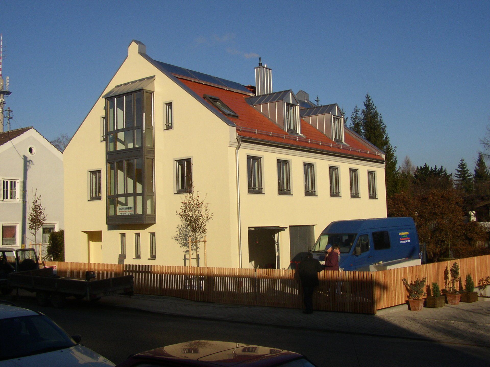 A yellow building with a blue van parked in front of it