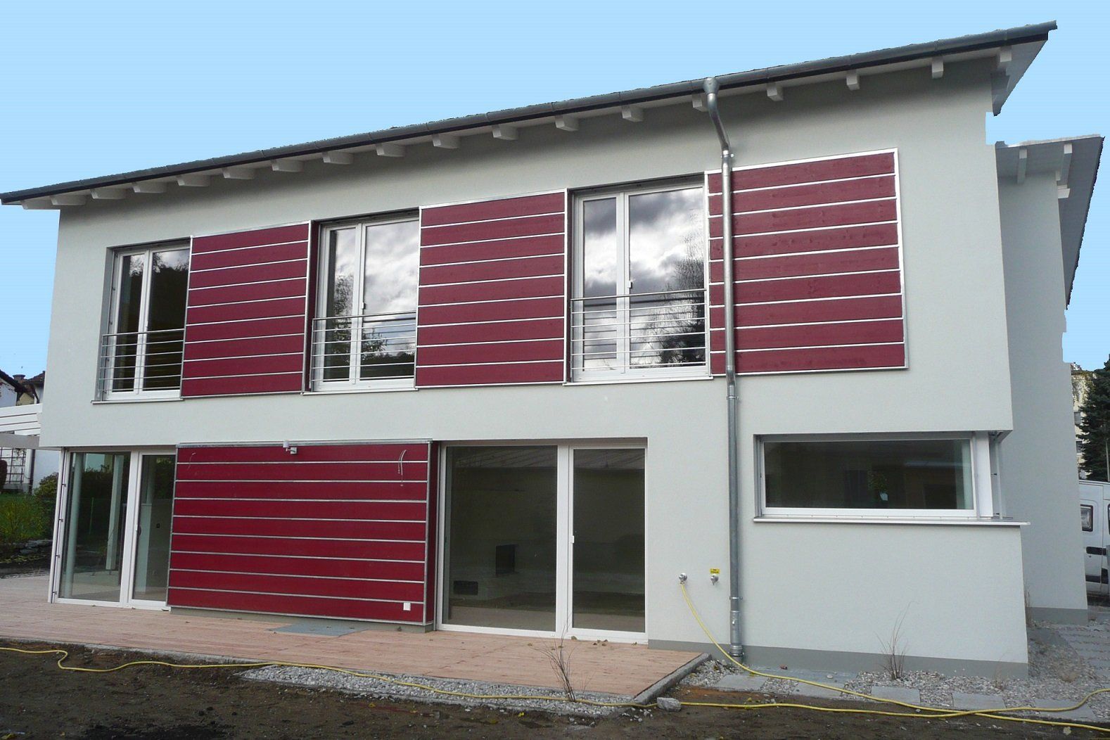 A white house with red shutters on the windows