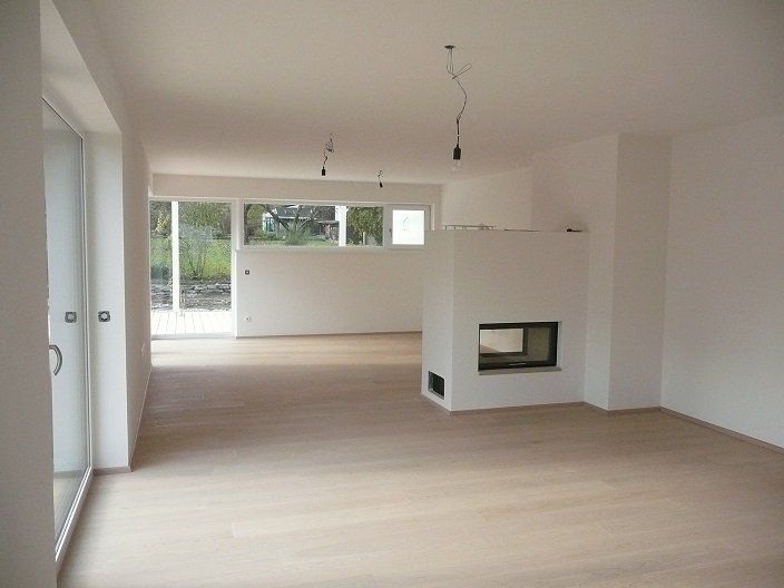 An empty living room with a fireplace and sliding glass doors
