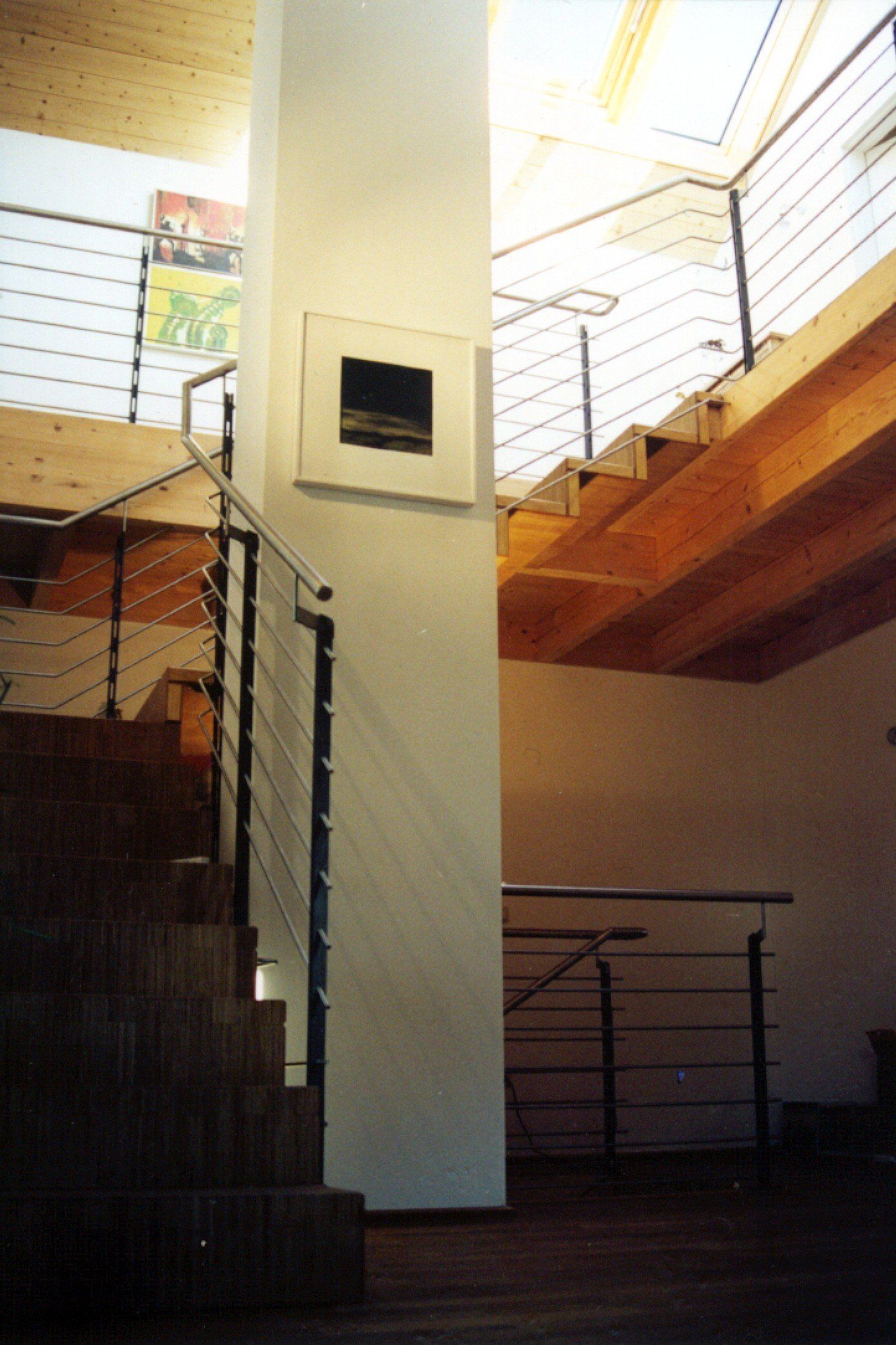 A staircase with a metal railing and a picture on the wall