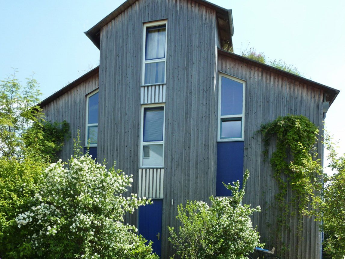 A large wooden house with blue doors and windows