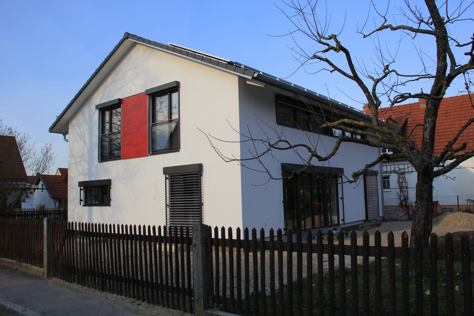 A white house with a wooden fence around it