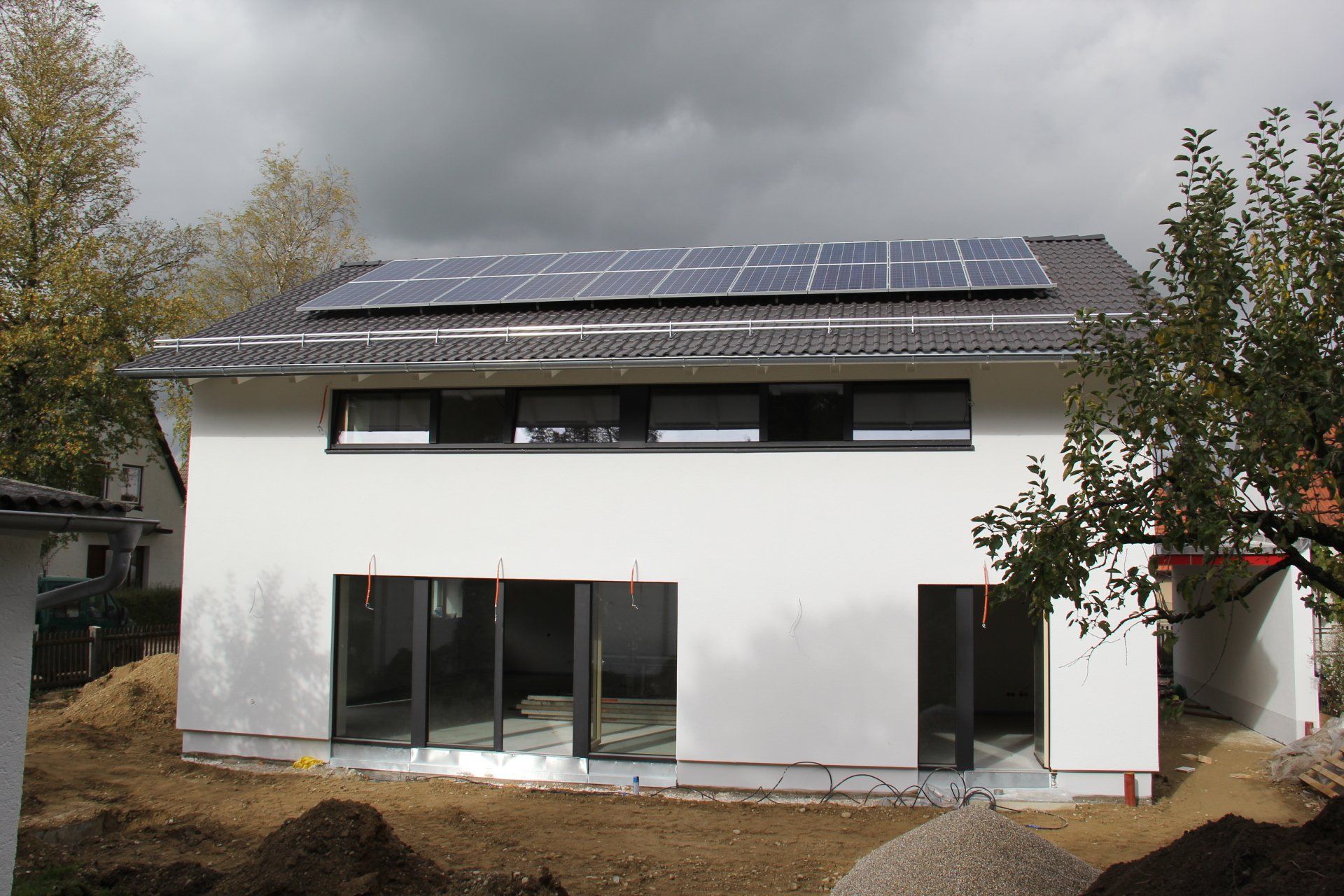 A white house with solar panels on the roof.