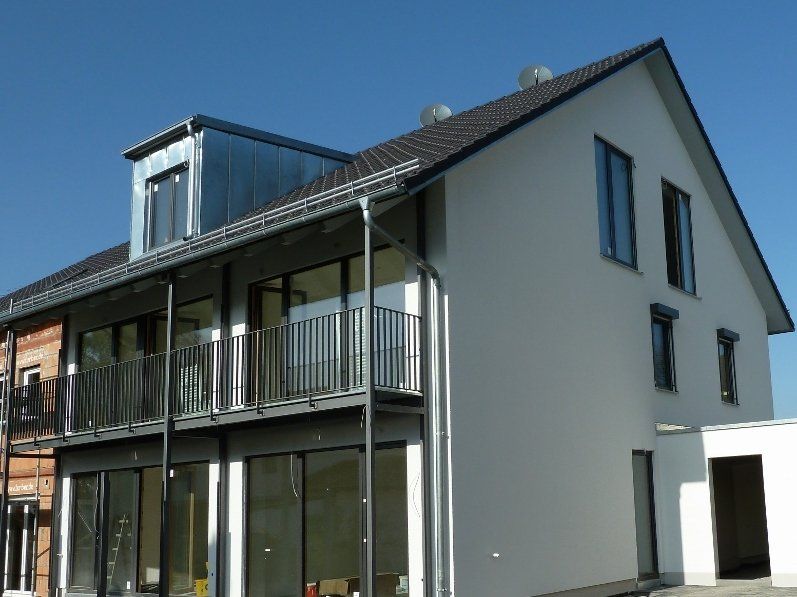 A white house with a balcony and a lot of windows