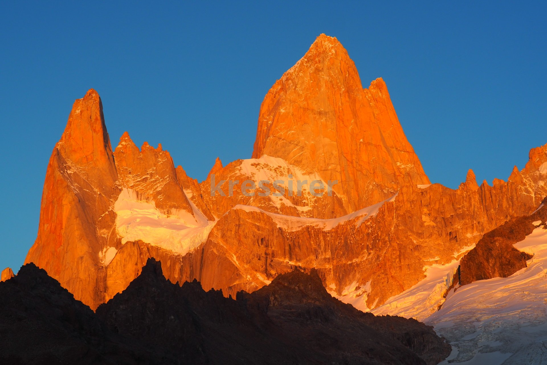 A mountain with a blue sky in the background