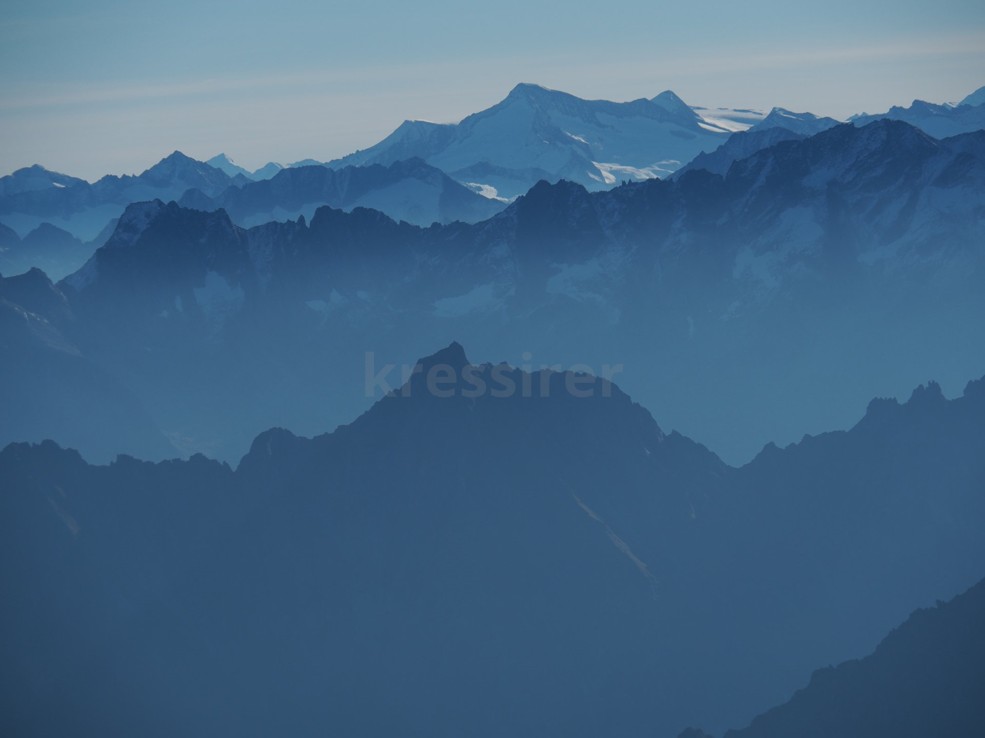 A view of a mountain range with a blue sky in the background