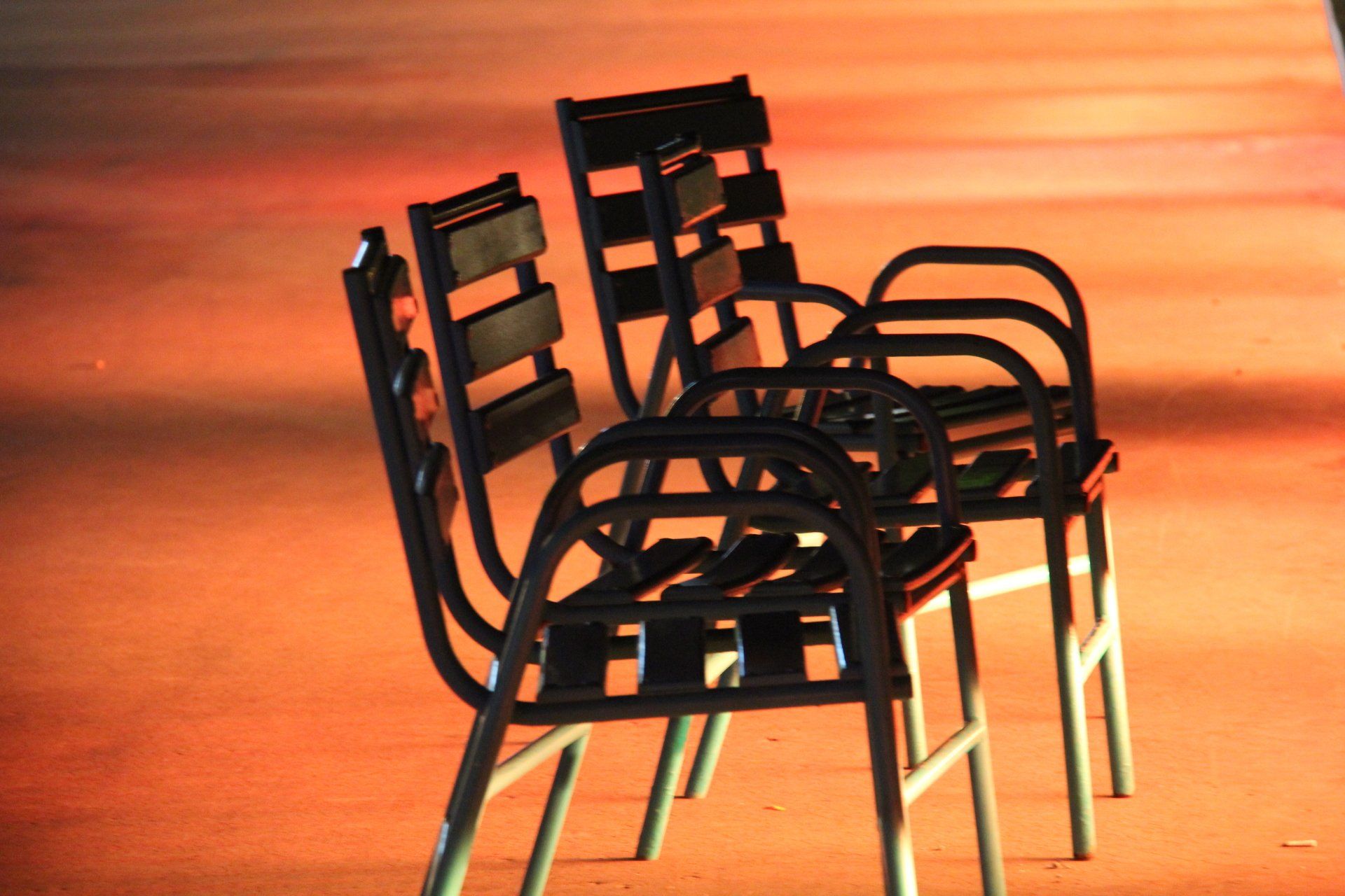 Four chairs are stacked on top of each other on a red carpet