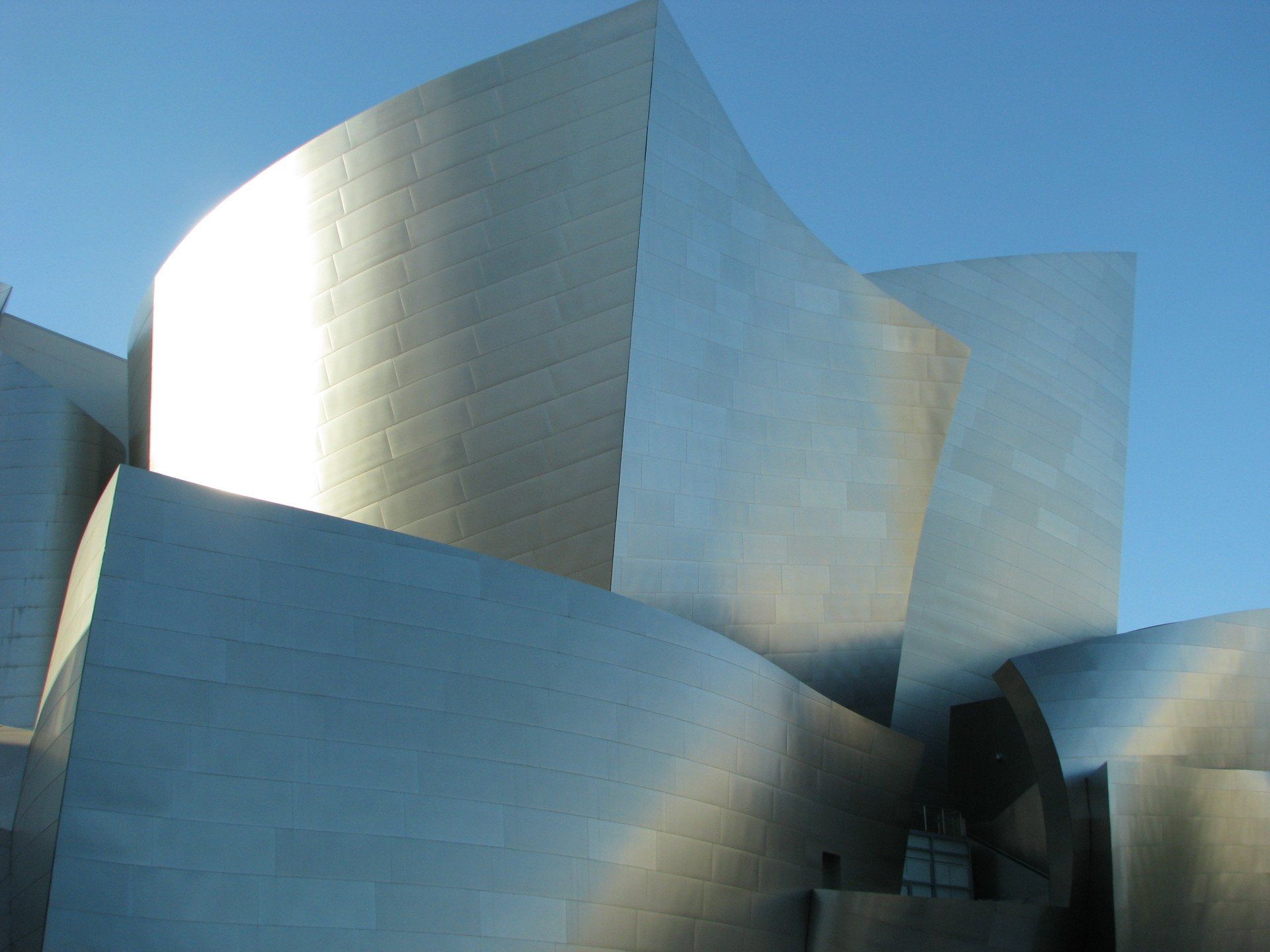 A large silver building with a blue sky in the background