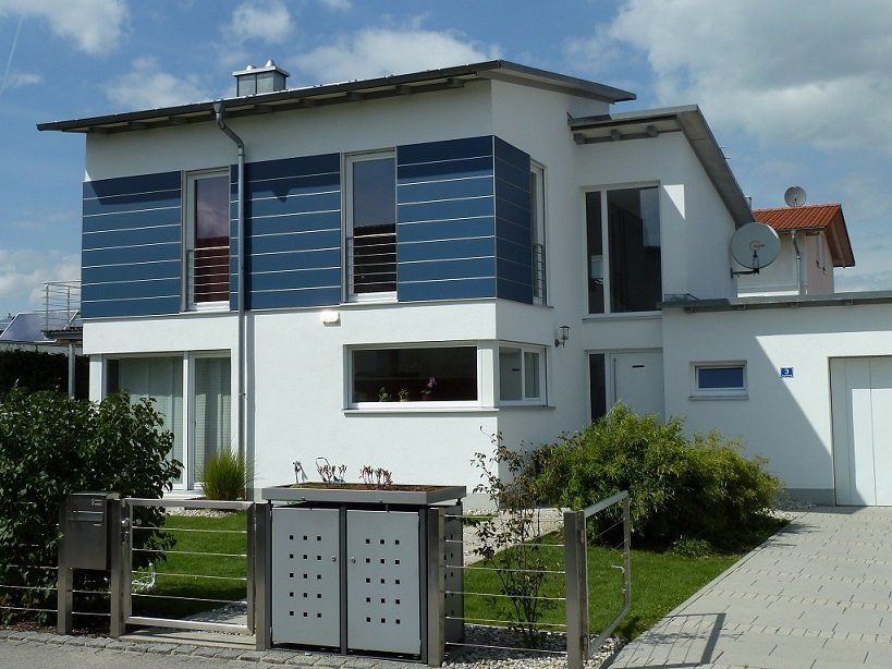 A white house with blue shutters on the windows