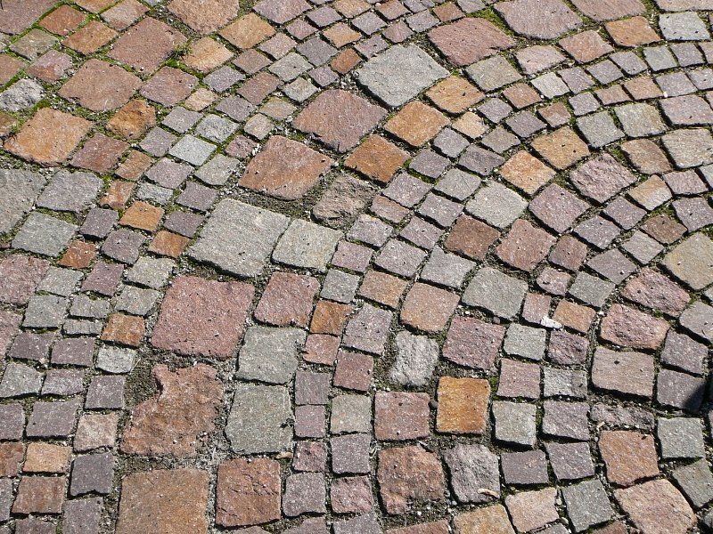 A close up of a cobblestone pavement with a circular pattern