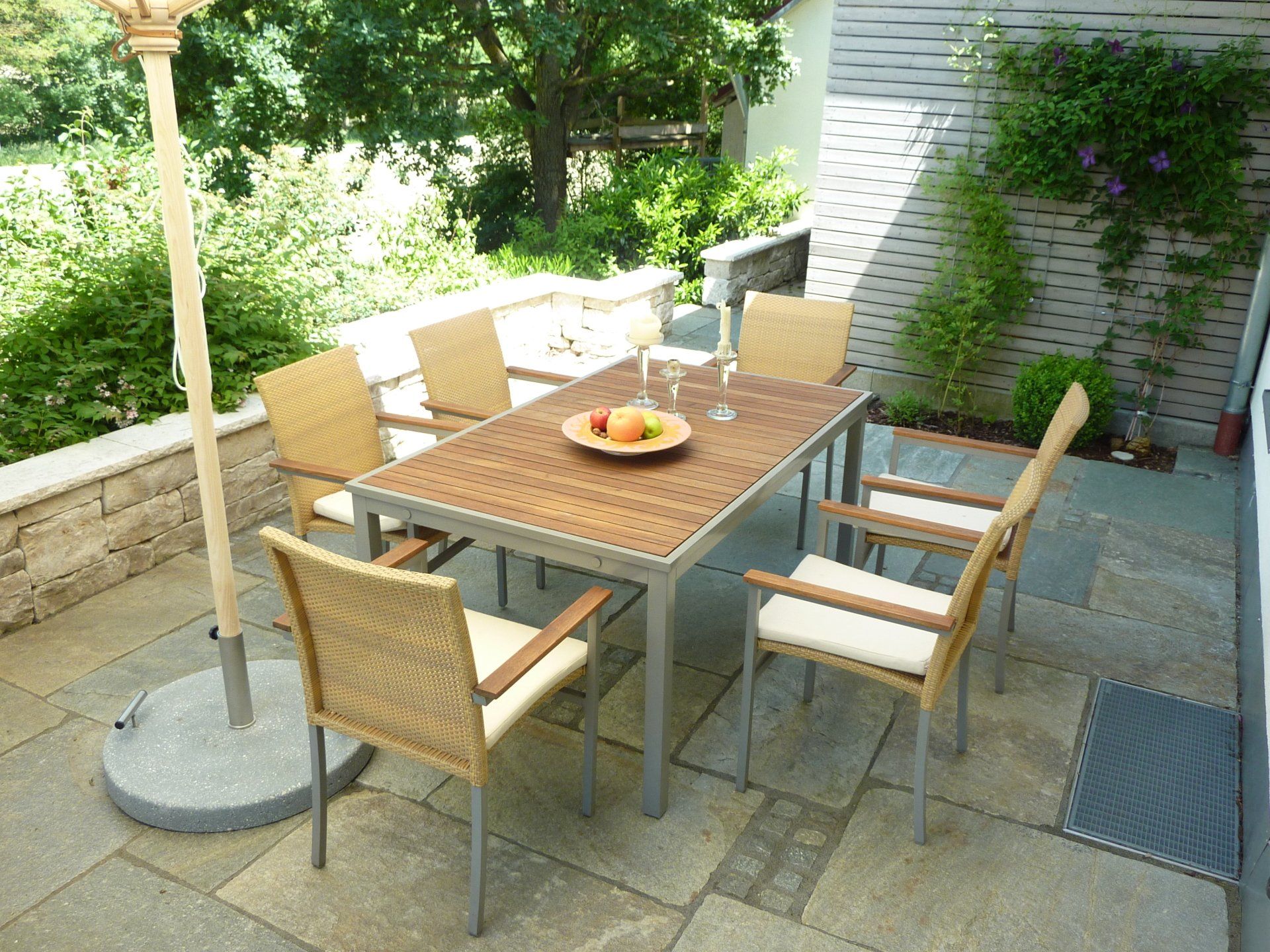 A table and chairs on a patio with an umbrella