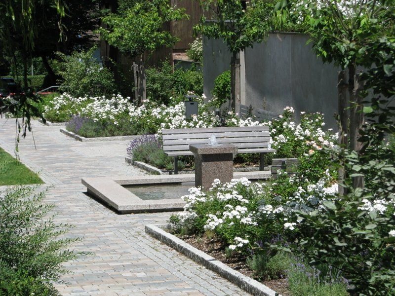 A park with a bench and a fountain in the middle