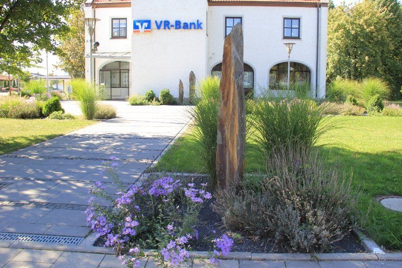 A white building with a blue sign that says vr-bank