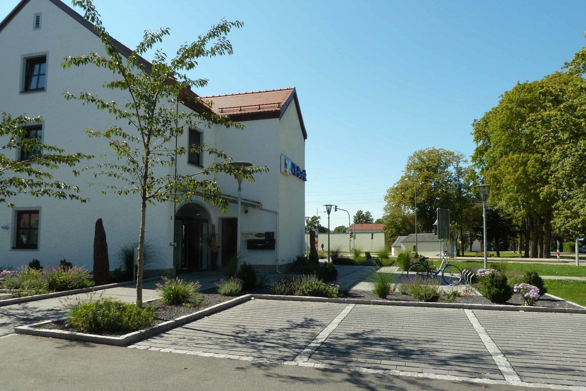 A white building with a parking lot in front of it