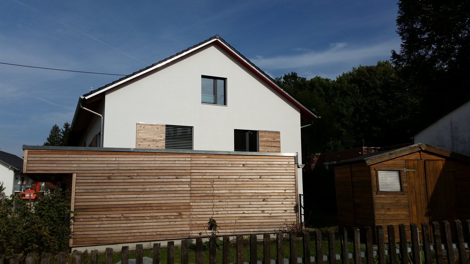 A white house with a wooden fence in front of it