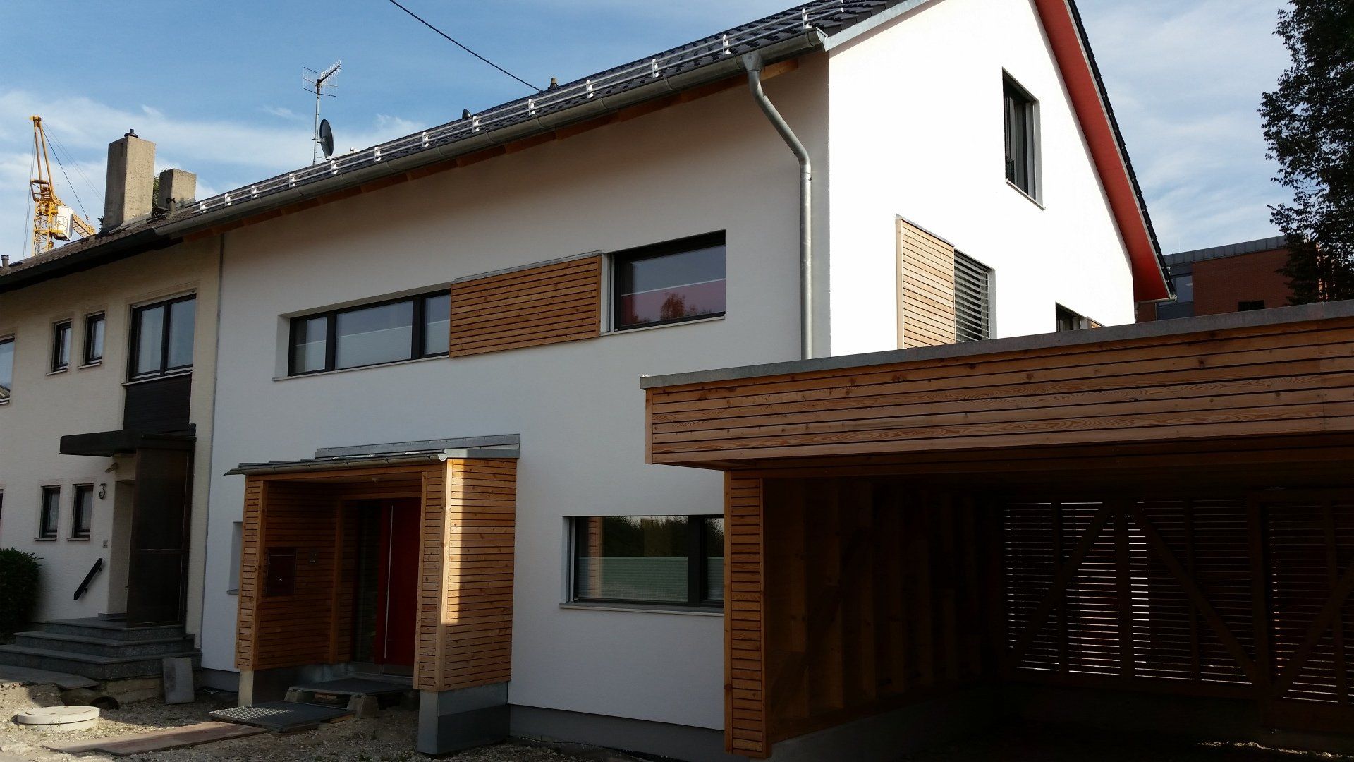 A white house with a wooden carport in front of it