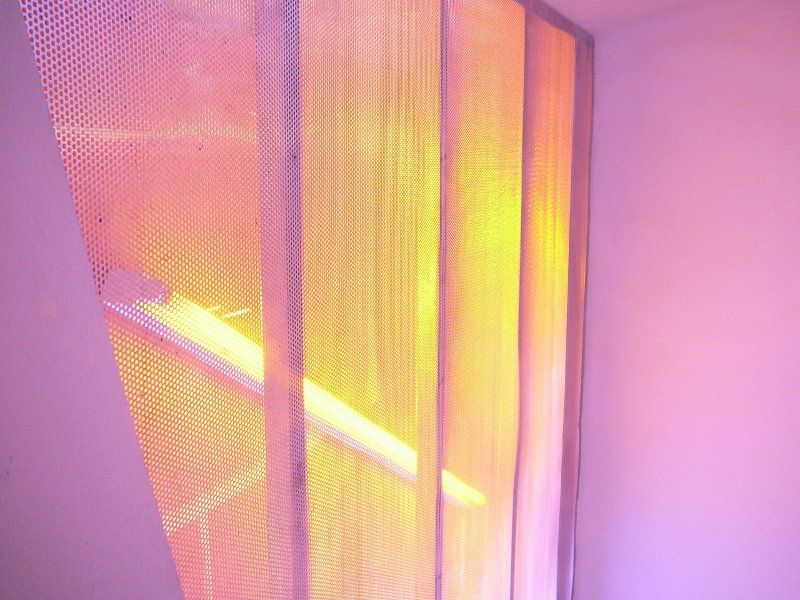 A close up of a curtain with a light shining through it.