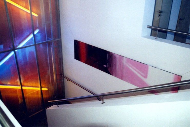 A staircase with a railing and a painting on the wall