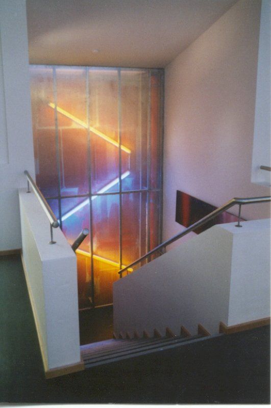 A staircase with a stained glass window behind it