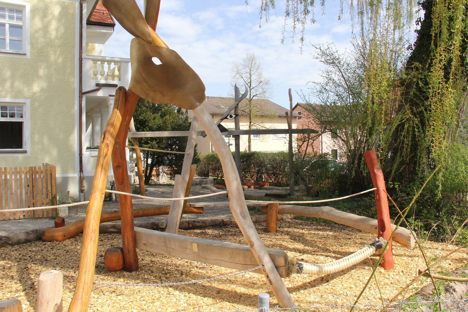 A playground with a wooden sculpture in the middle of it