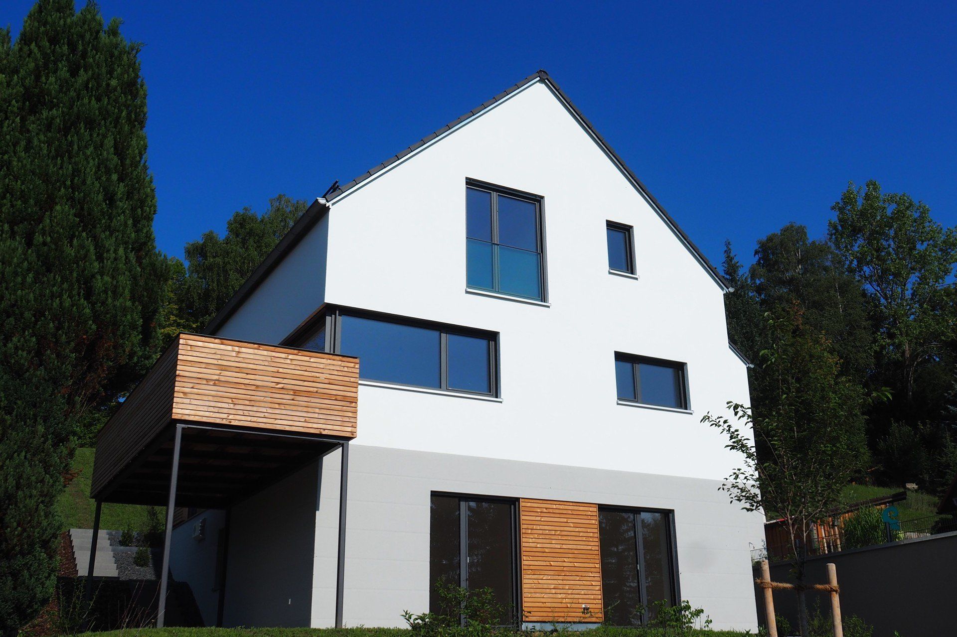 A white house with a balcony and a blue sky in the background