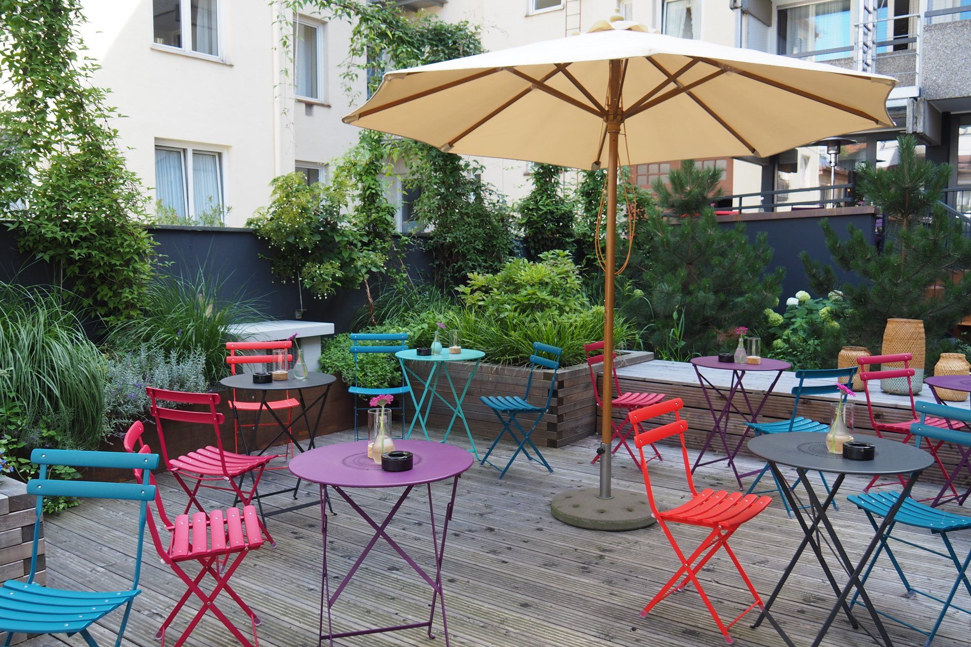 A patio with tables and chairs under an umbrella