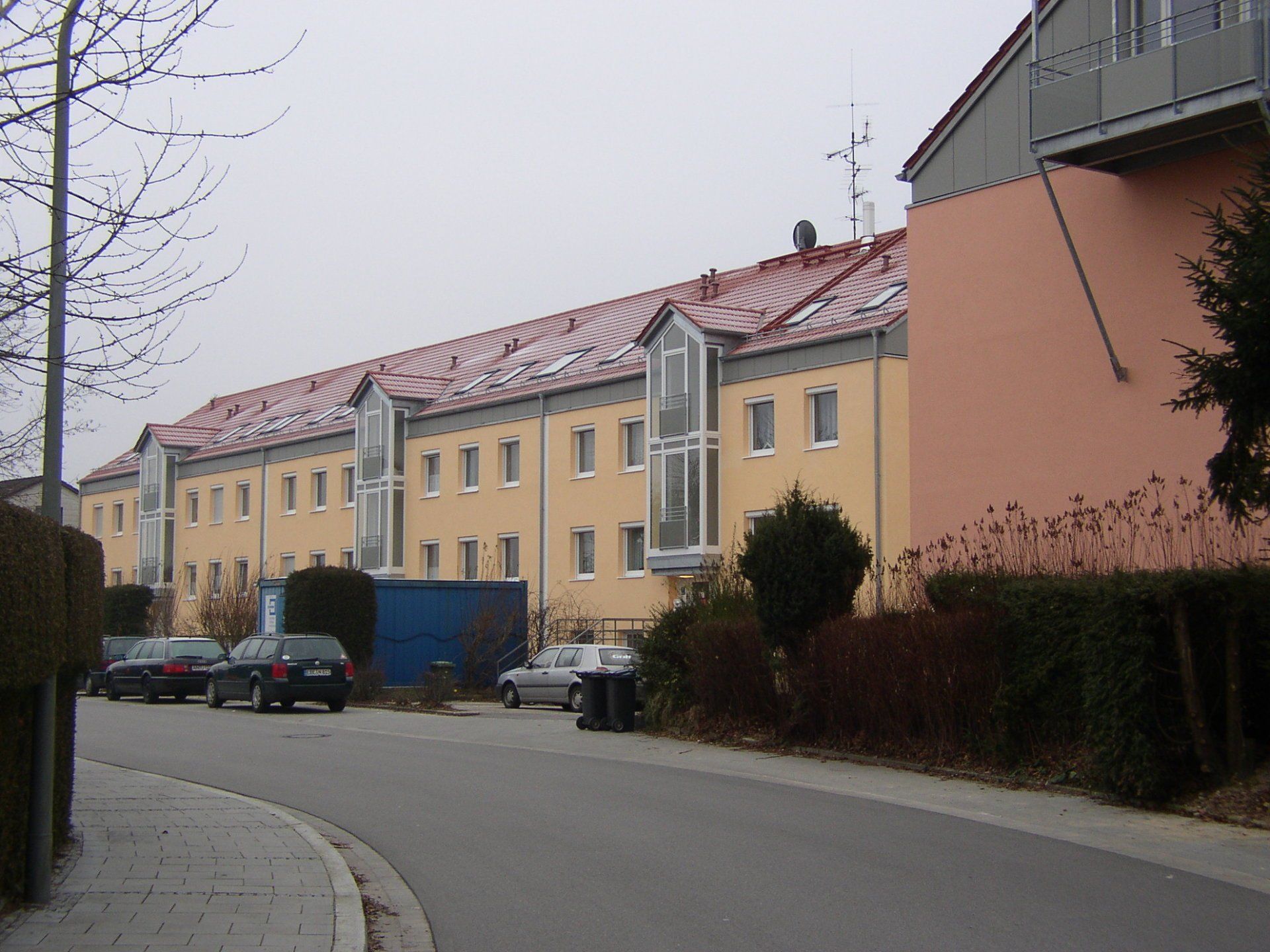 A row of buildings with cars parked in front of them