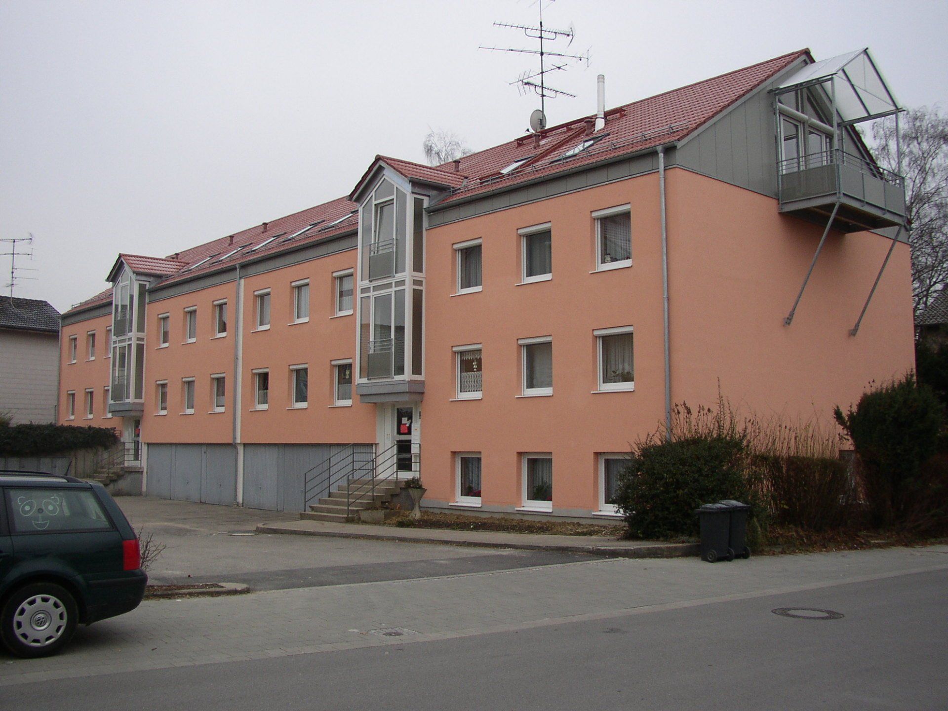 A car is parked in front of a large building