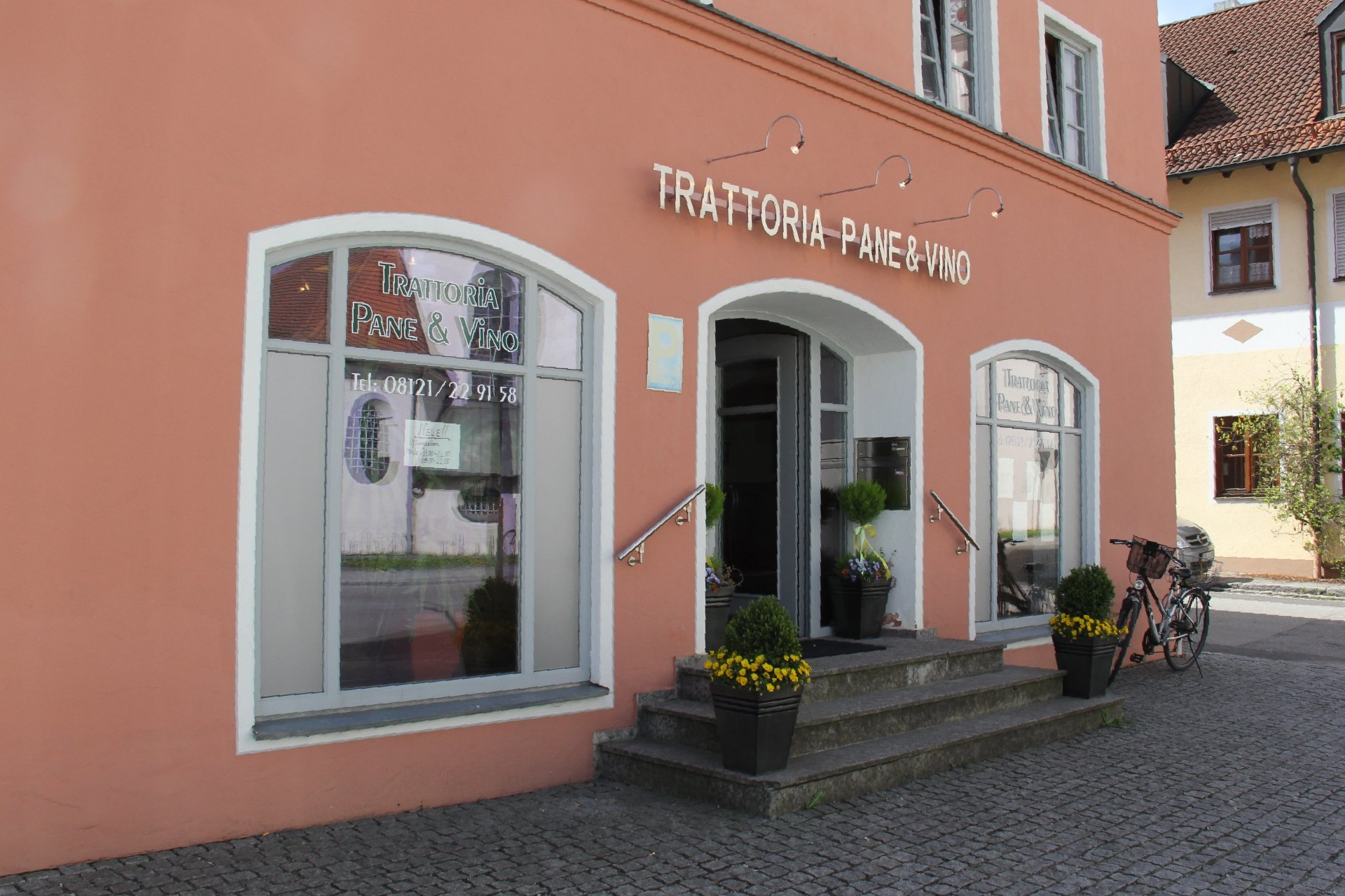 A pink building with a bicycle parked in front of it