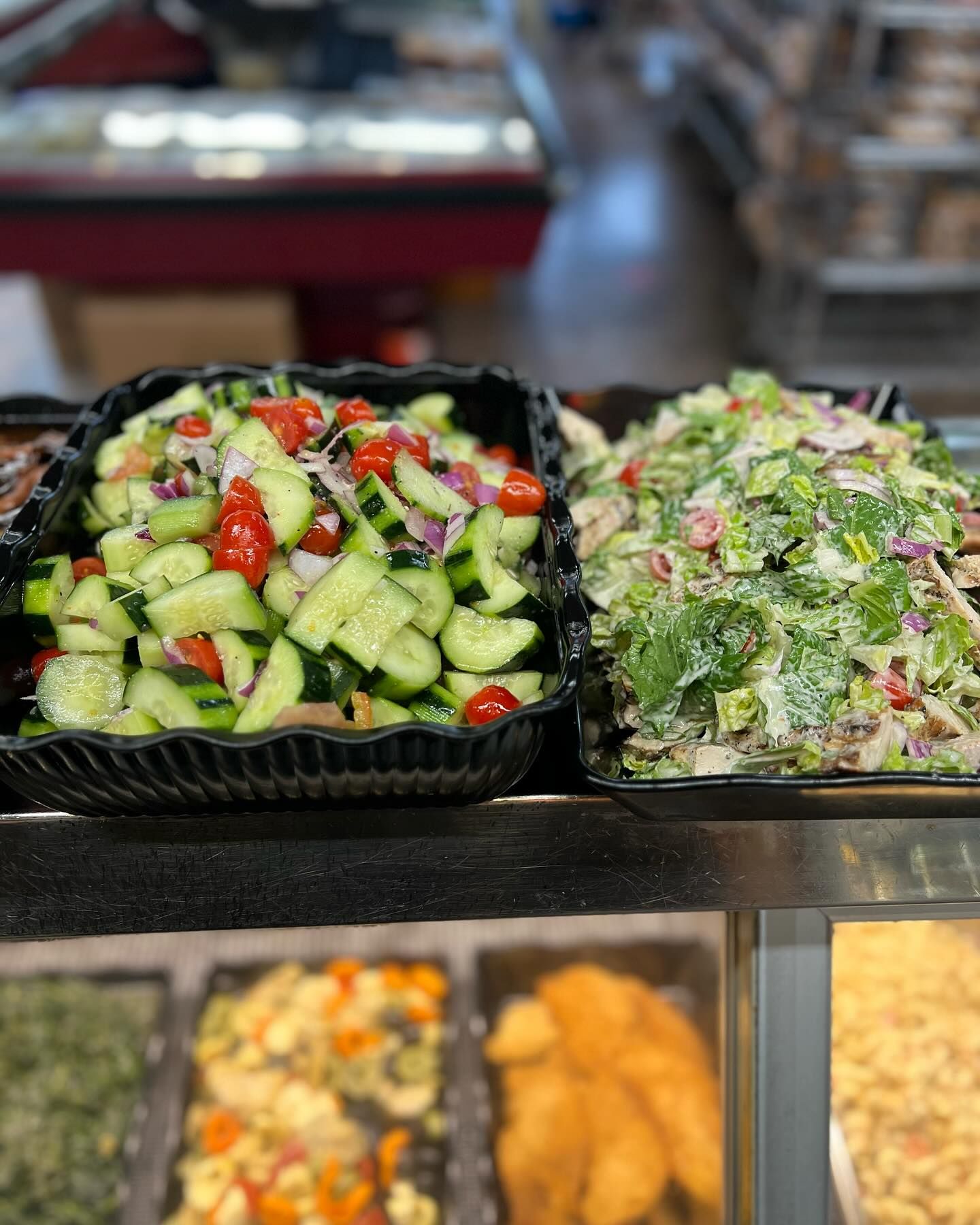 A variety of salads are sitting on a buffet table.