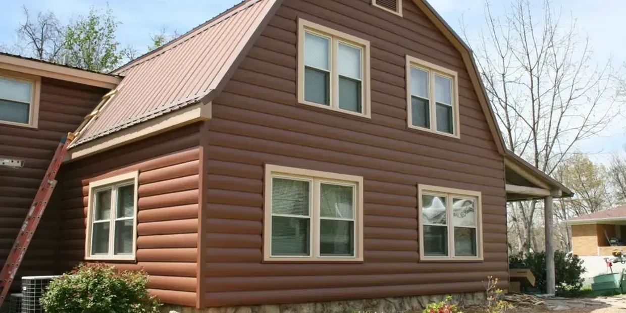 A log cabin with a red roof and a lot of windows