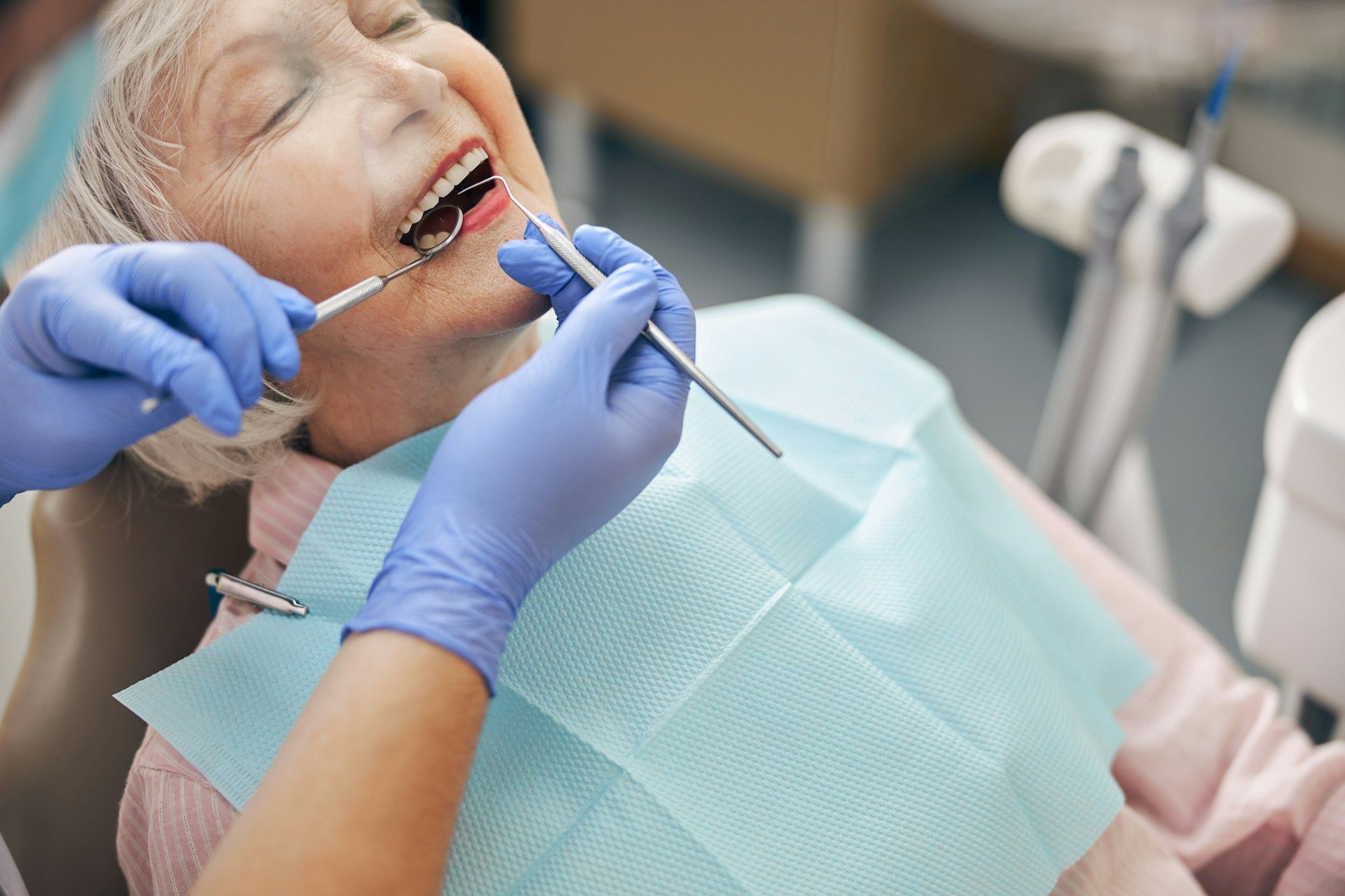 A woman is having her teeth examined for cosmetic dentistry by a dentist.