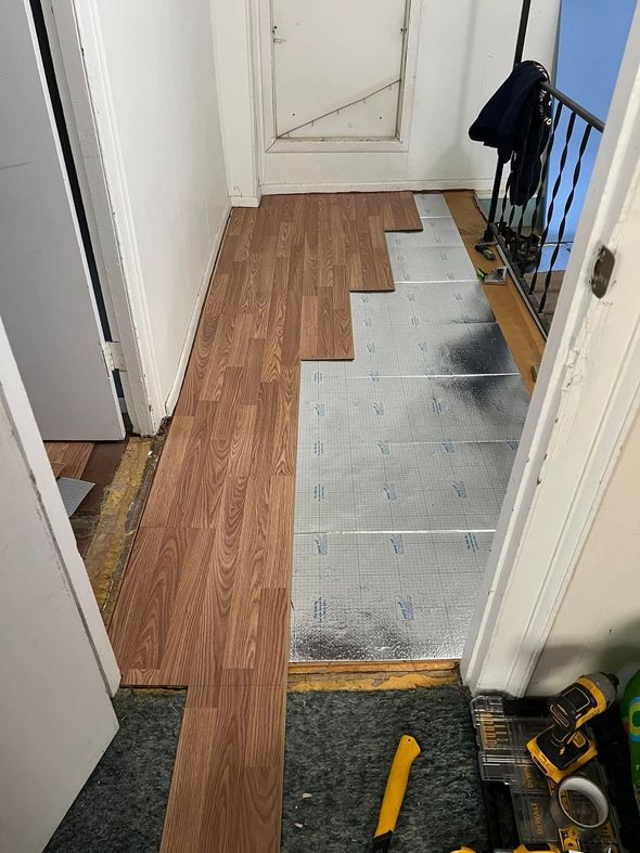 Hallway with wood flooring installation in progress; wood planks and underlayment visible.