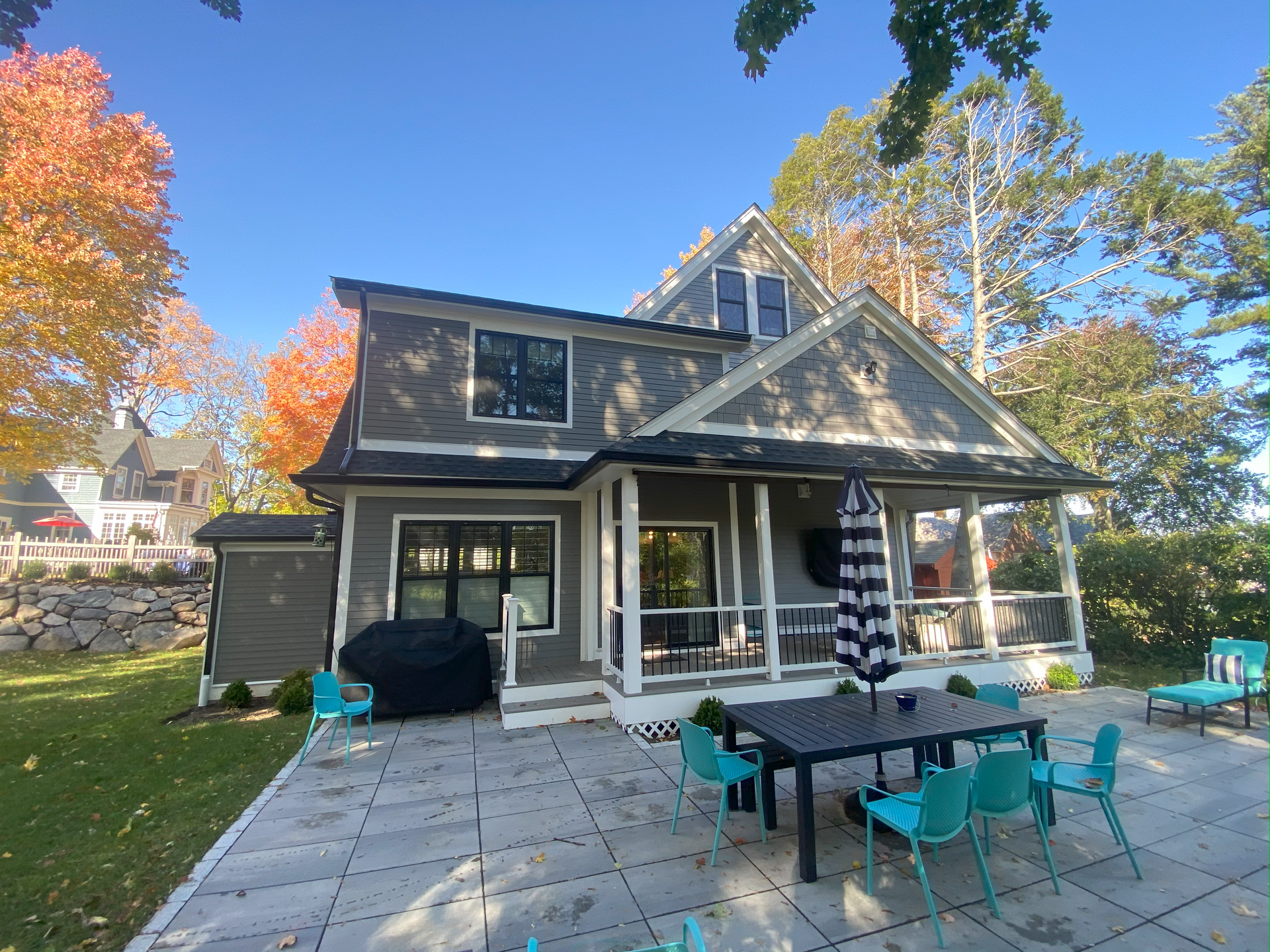 The back of a house with a table and chairs on the patio