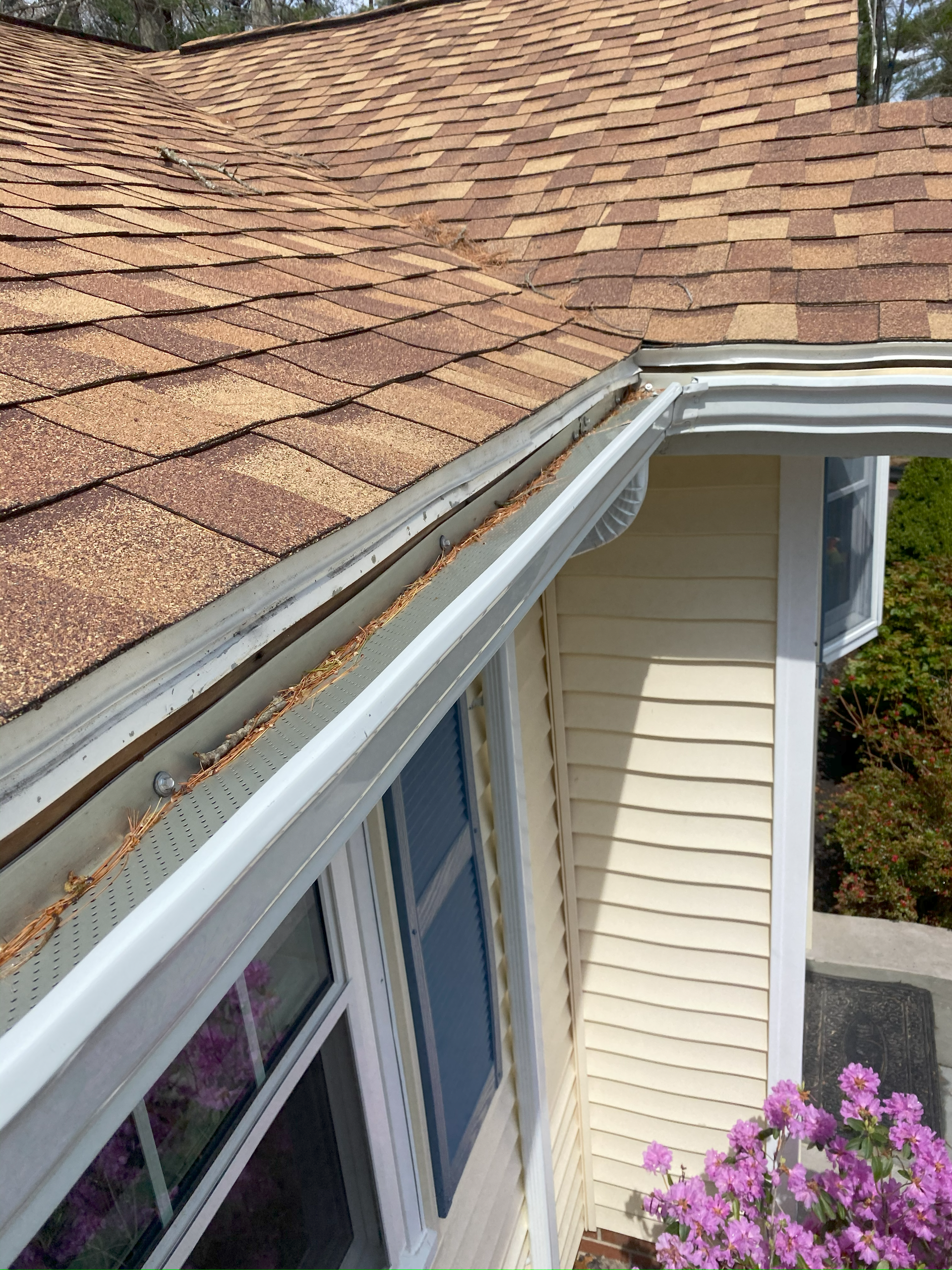 A house with a gutter on the side of it and a roof.
