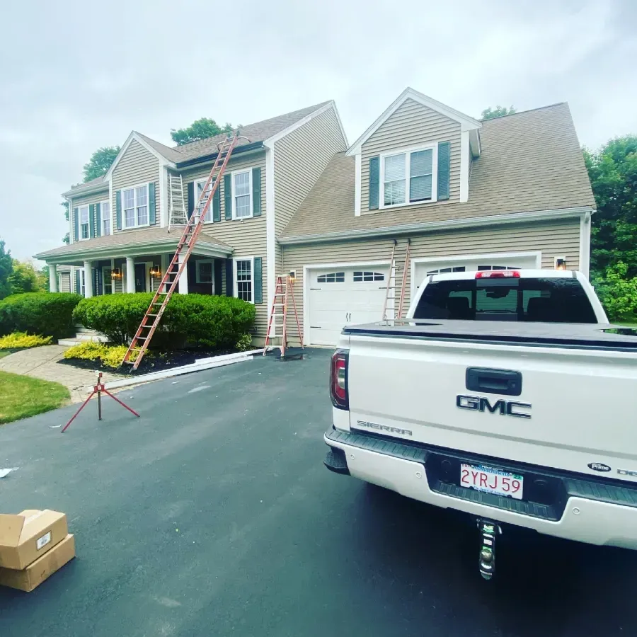 A white gmc truck is parked in front of a house.