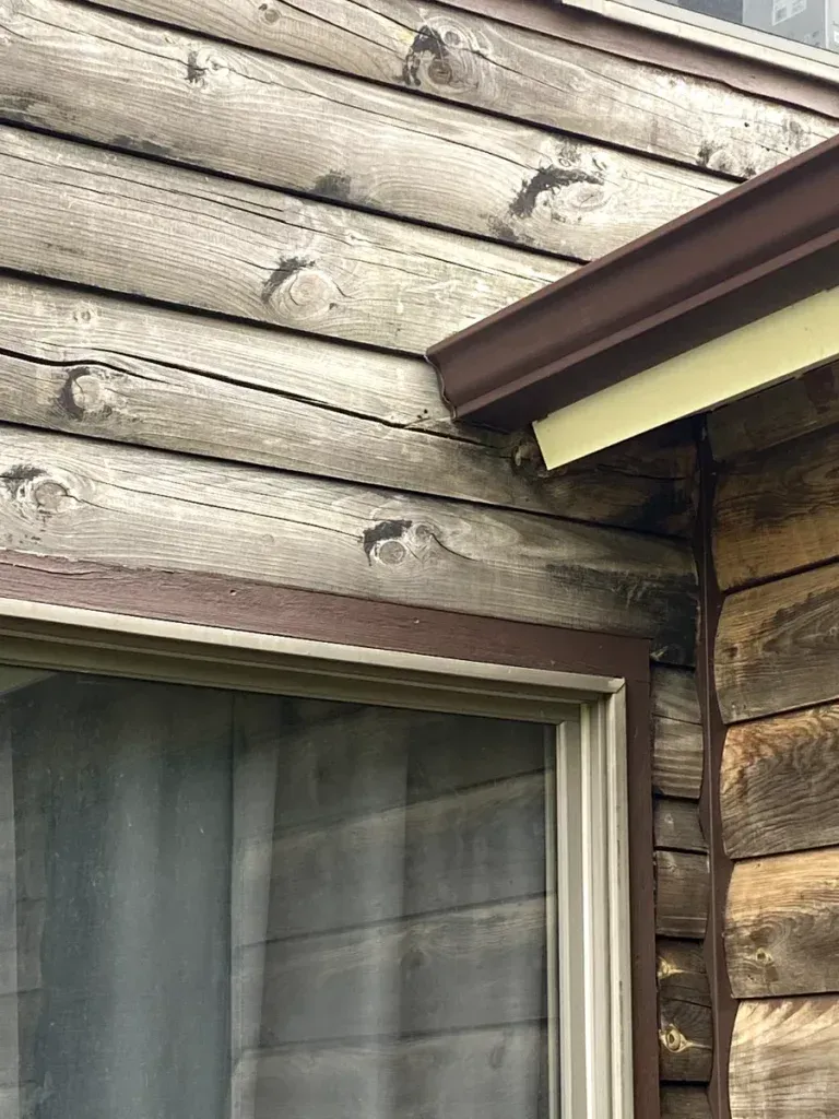 A close up of a window on a wooden house.