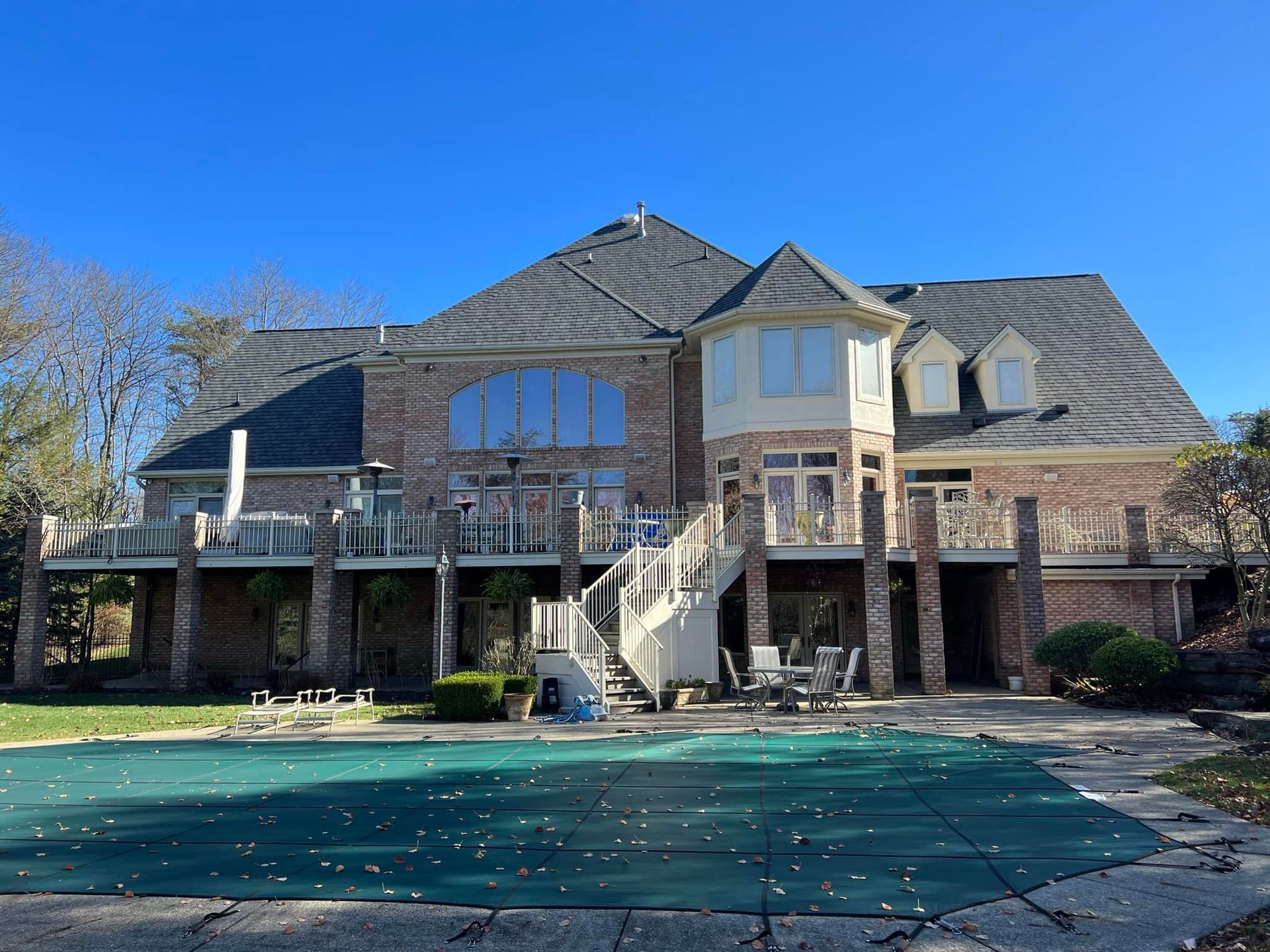 A large house with a swimming pool in front of it