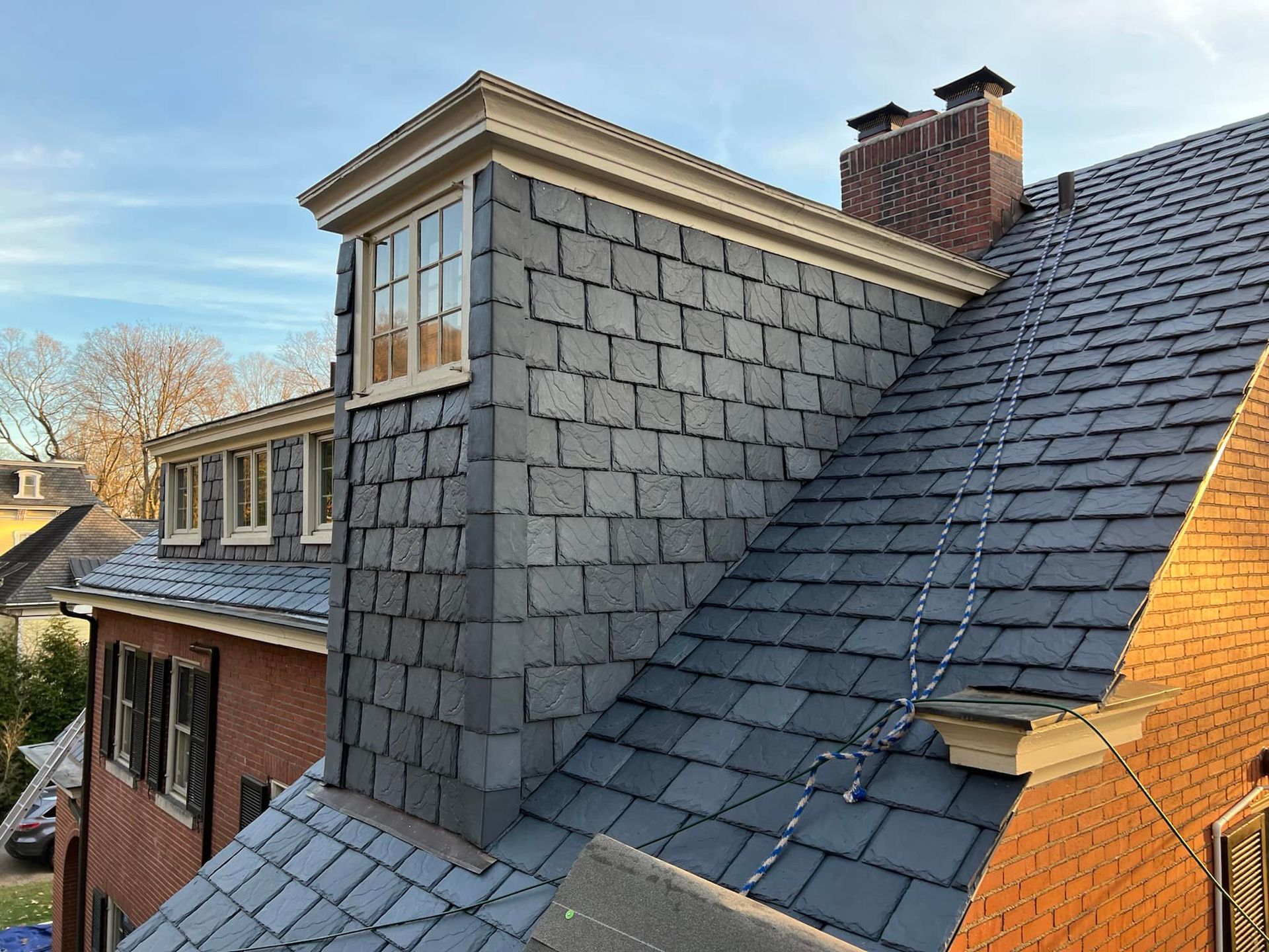 A brick house with a slate roof and chimney.