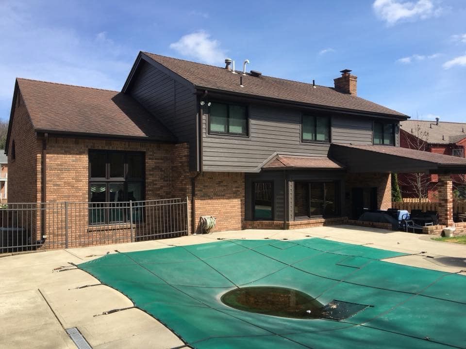 A large house with a swimming pool in front of it