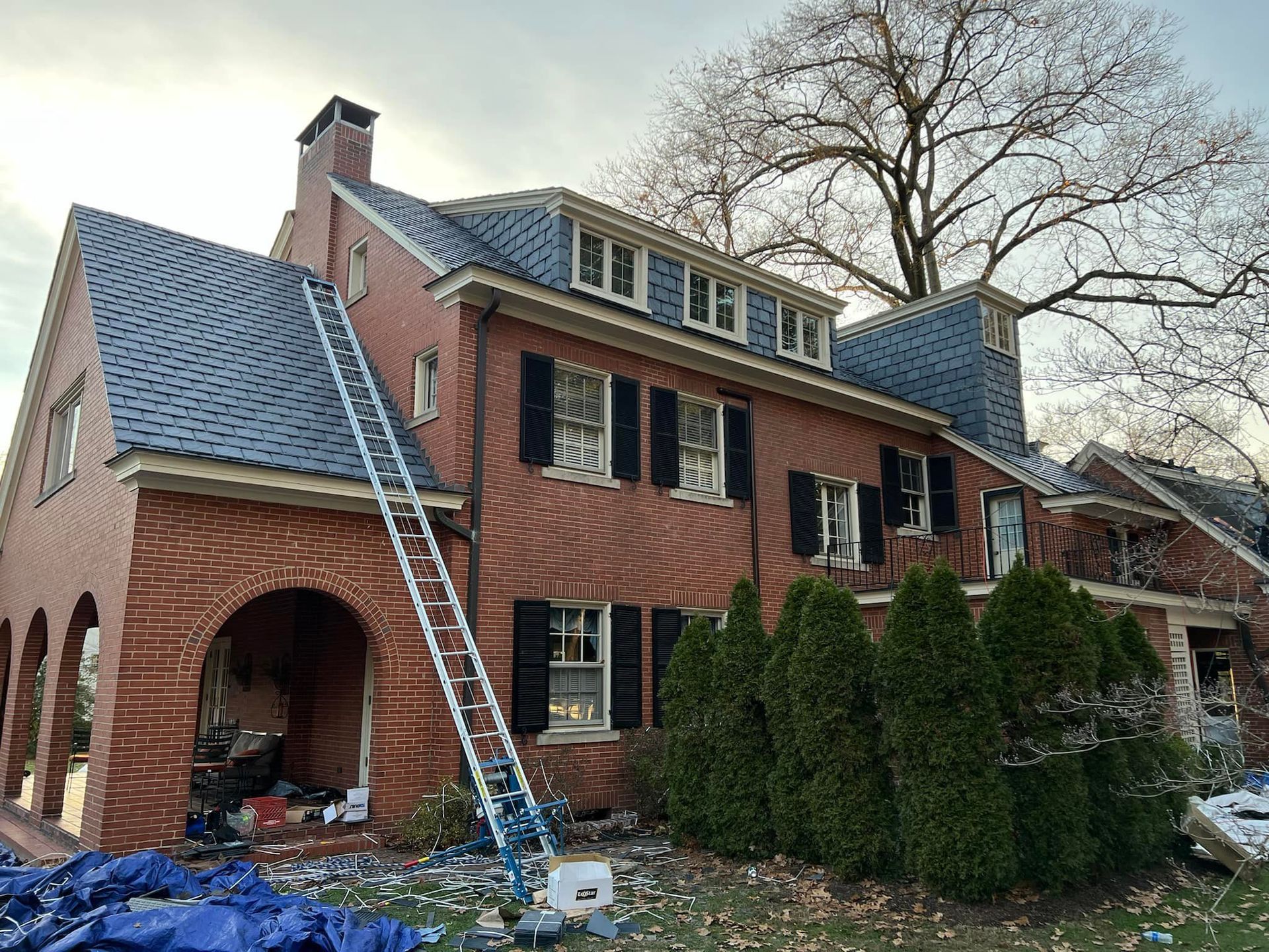 A large brick house with a ladder on the side of it.