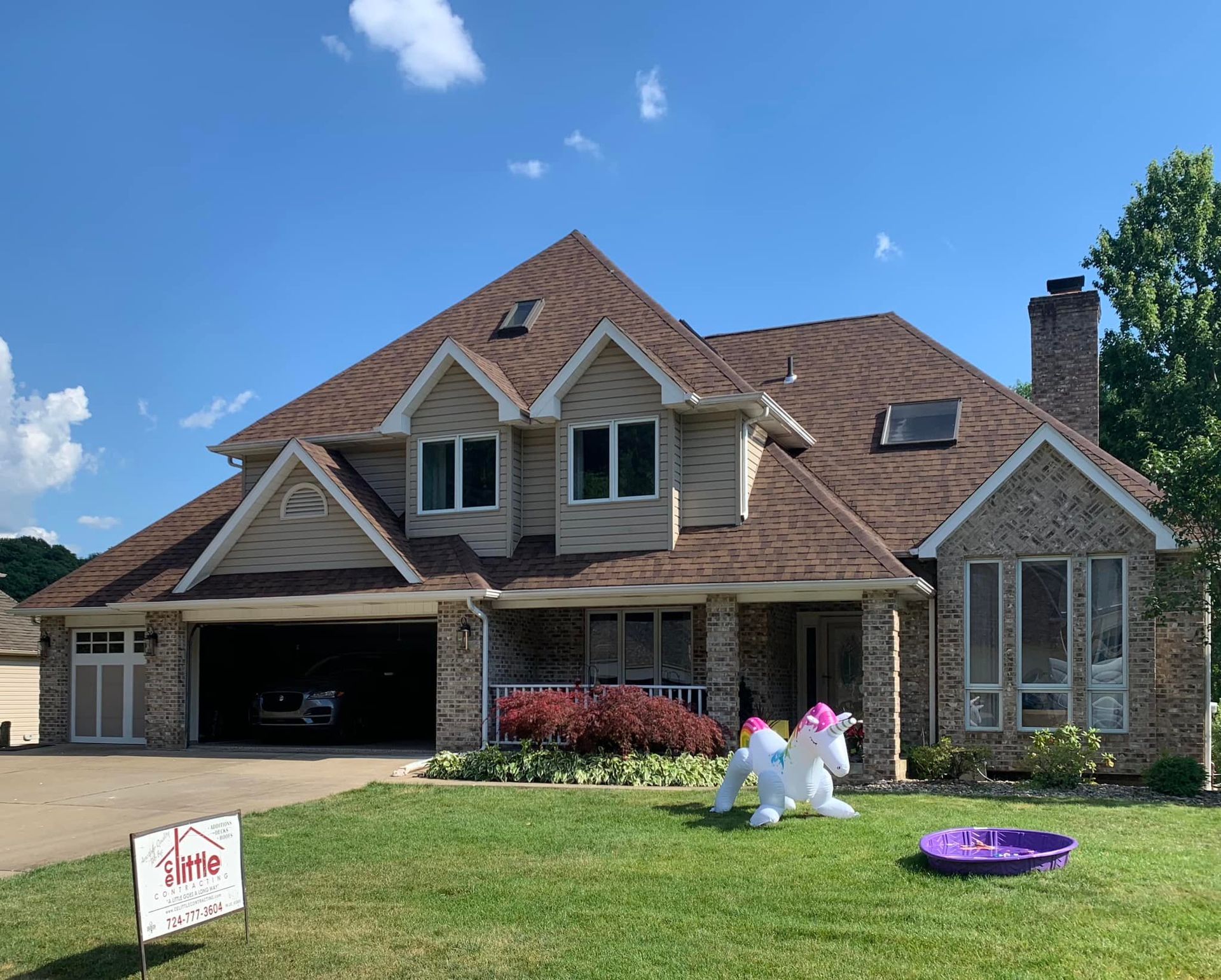A large house with a unicorn inflatable in front of it.