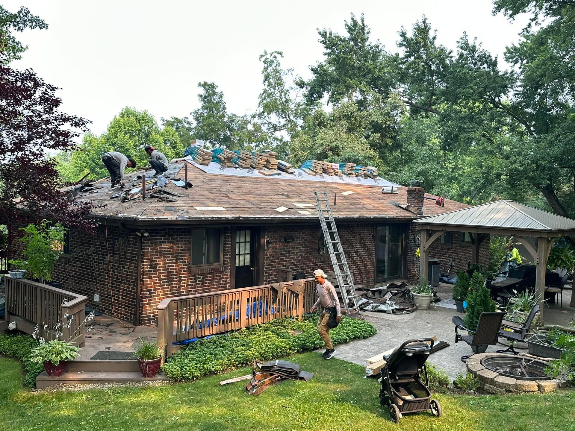 A group of people are working on the roof of a house.