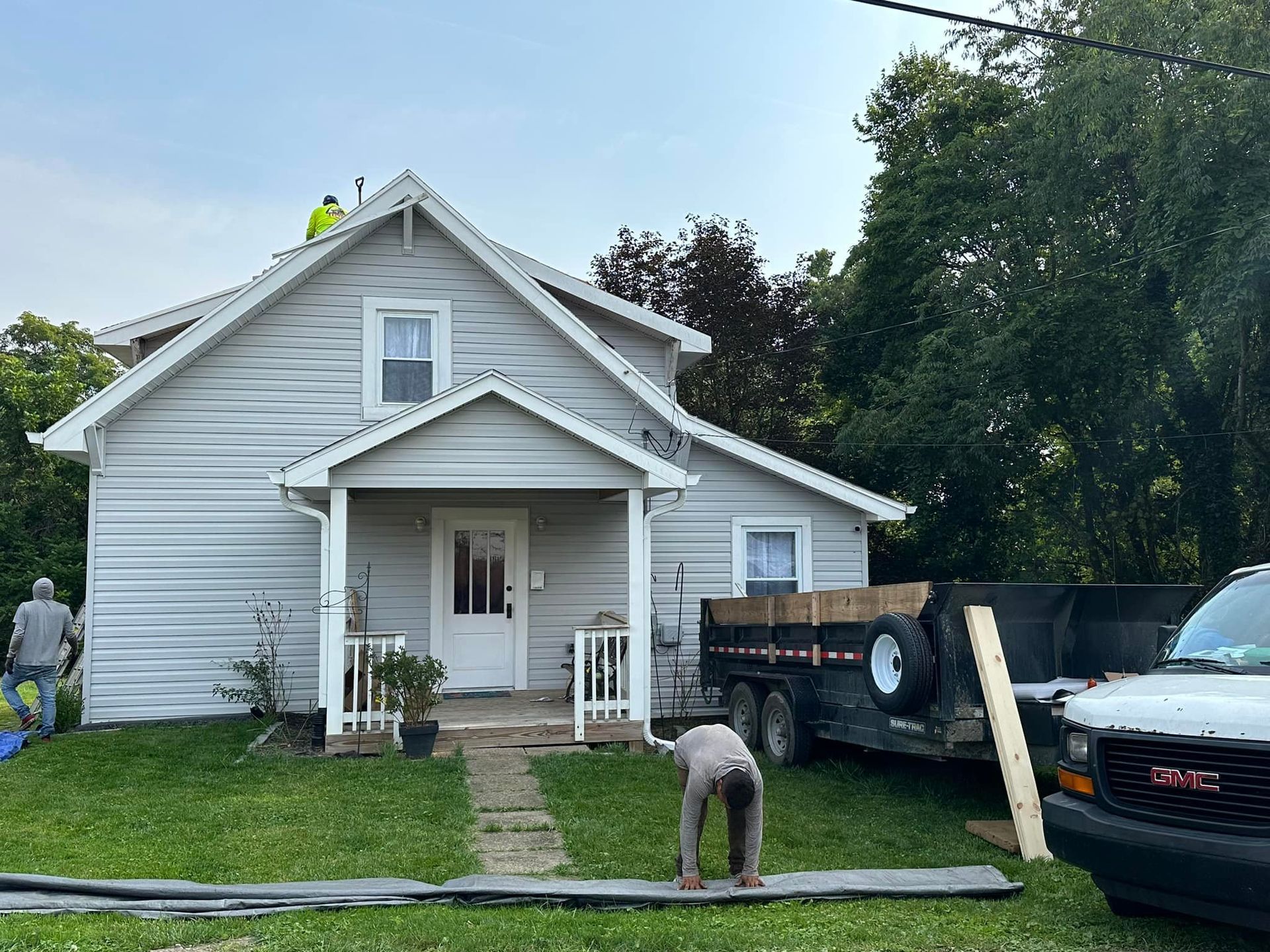 Two men are working on the roof of a house.