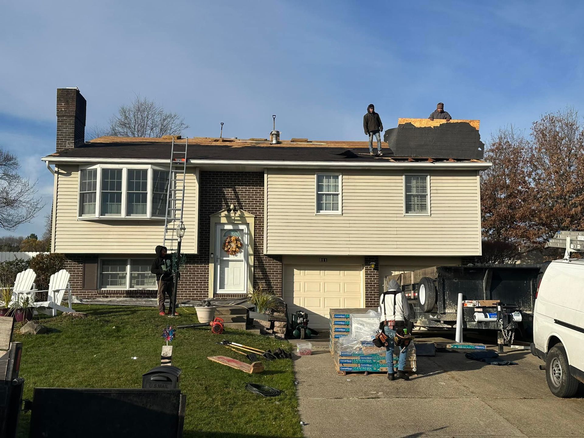 Two men are working on the roof of a house.