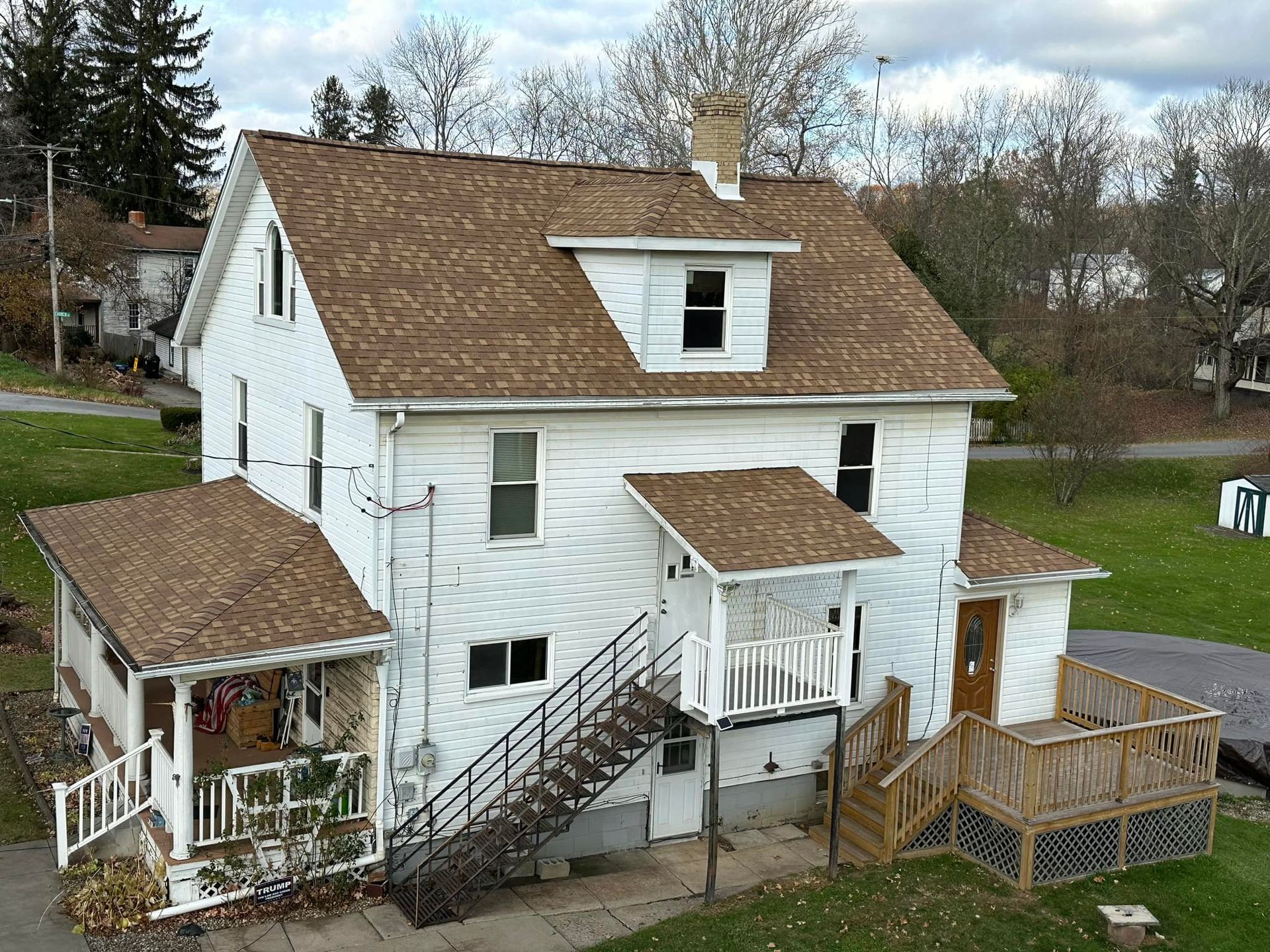 An aerial view of a white house with a brown roof.