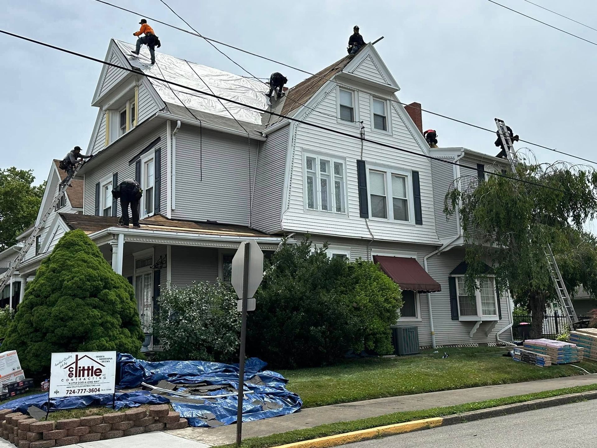 A group of people are working on the roof of a house.