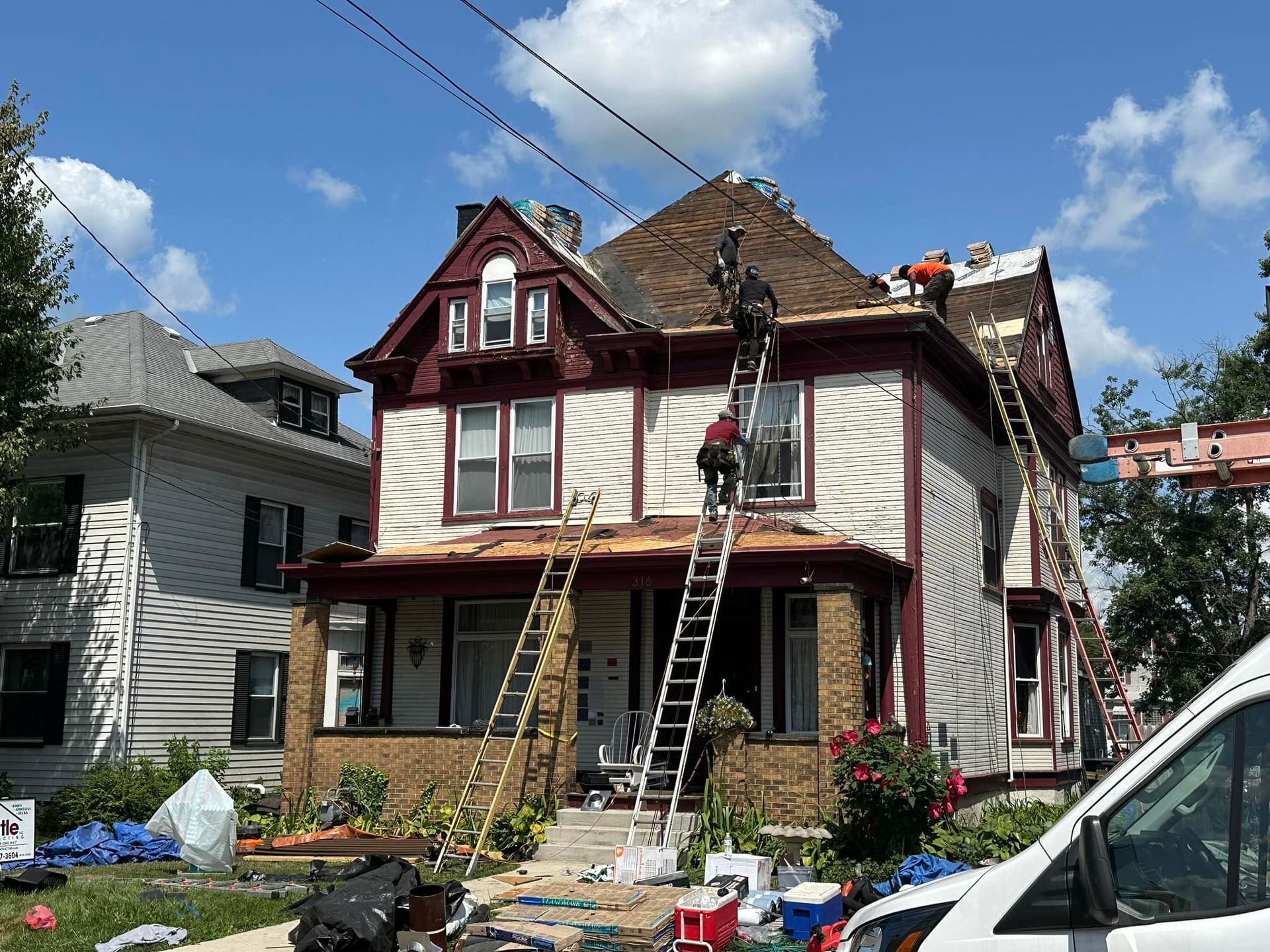 A group of people are working on the roof of a house.